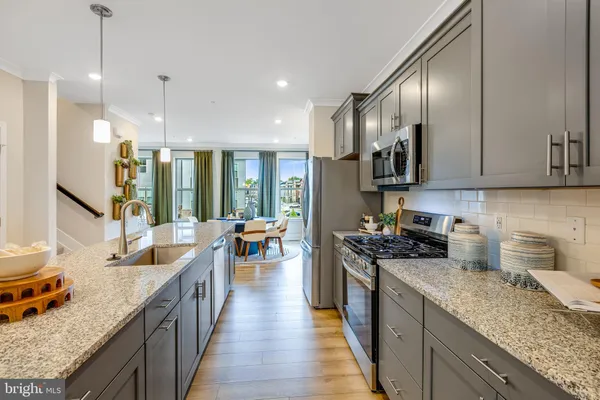 a kitchen with granite countertop lots of counter top space a sink stainless steel appliances and cabinets