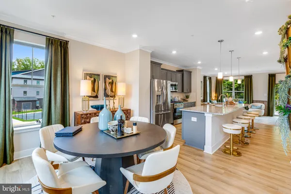 a kitchen with a dining table chairs and refrigerator