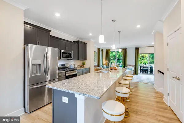 a large kitchen with granite countertop a large counter top stainless steel appliances and cabinets