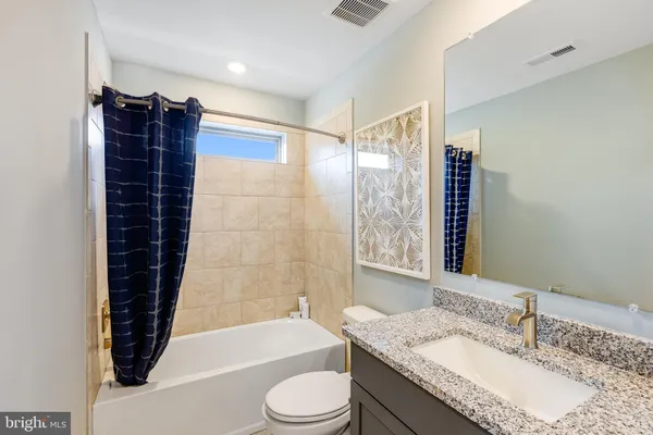 a bathroom with a granite countertop sink toilet and shower