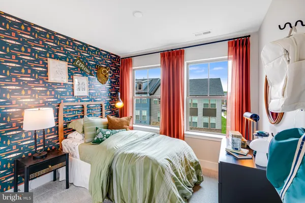 a bedroom with a bed and large windows