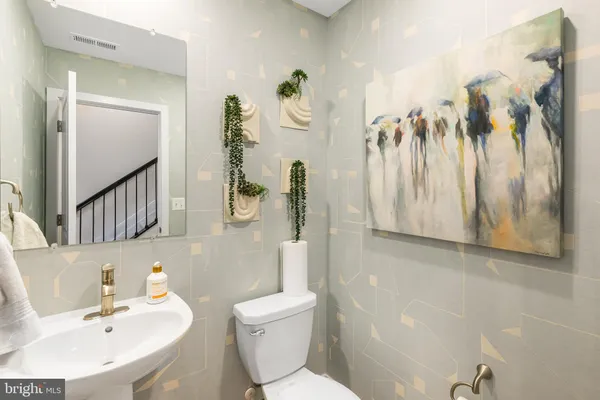 a bathroom with a sink a toilet and a mirror