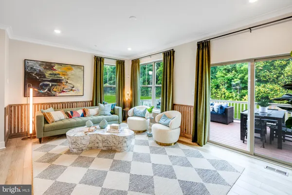 a living room with furniture and large windows with garden view