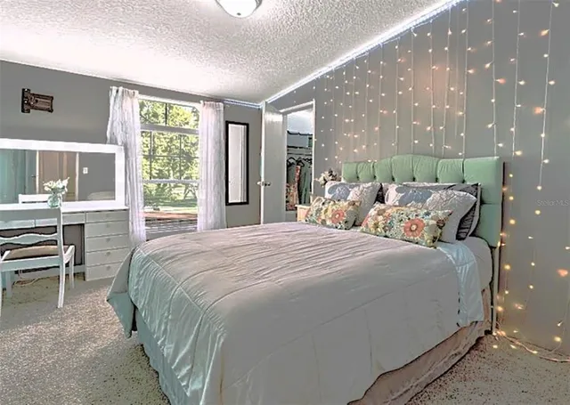 a bedroom with bed and large windows