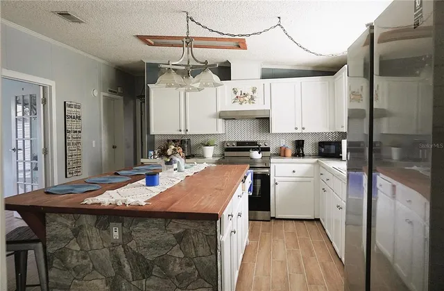 a kitchen with a table chairs refrigerator and cabinets