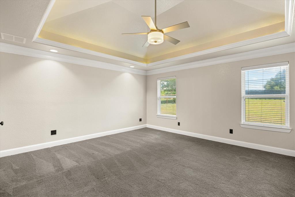 3711 Lonesome Creek Road Granbury, TX 76049 - Photo 14 of 39 Owners Suite with cozy neutral pallet and decorative tray ceiling and up lighting.