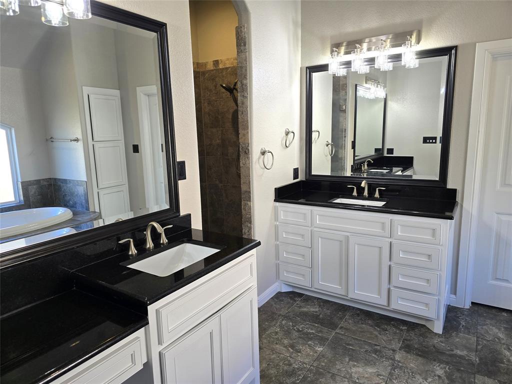 3711 Lonesome Creek Road Granbury, TX 76049 - Photo 16 of 39 Fabulous ensuite bath featuring freshly painted double vanities, one with tuck under seating, separate walk in shower, large jetted tub and tons of storage.