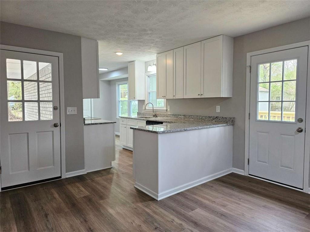 6470 Michell Way Douglasville, GA 30135 - Photo 11 of 41 a kitchen with granite countertop wooden floors white cabinets and stainless steel appliances
