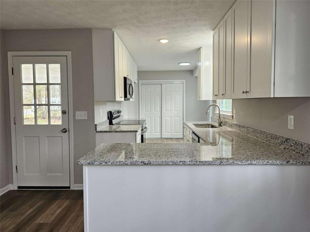 6470 Michell Way Douglasville, GA 30135 - Photo 12 of 41 a kitchen with kitchen island granite countertop a sink window and cabinets