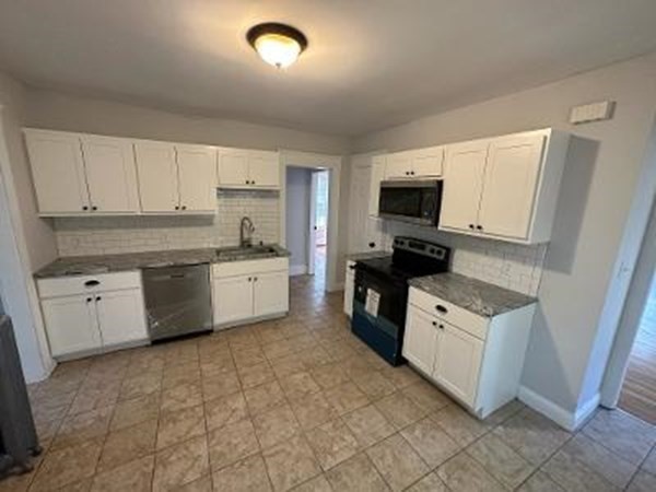 37-39 Fountain Street Springfield, MA 01108 - Photo 4 of 13 a kitchen with granite countertop a sink a stove top oven and white stainless steel appliances