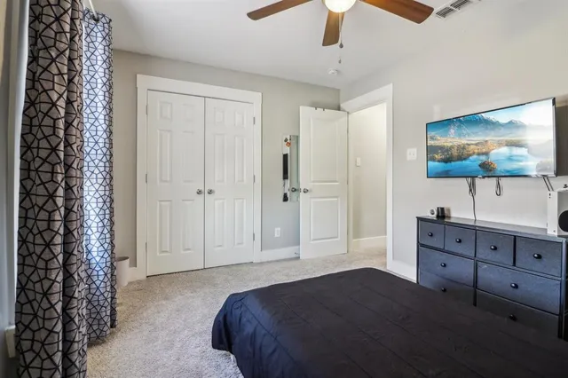 a bedroom with a bed and a flat tv screen on dresser