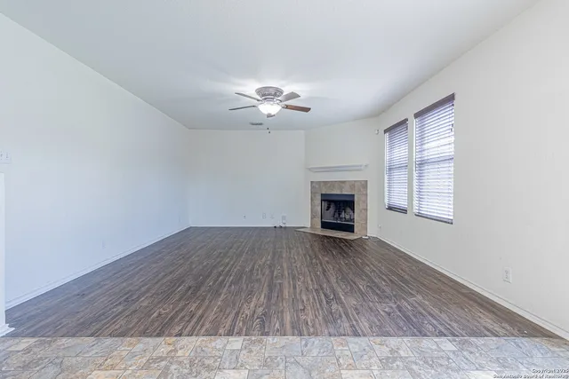 wooden floor fireplace and windows in an empty room