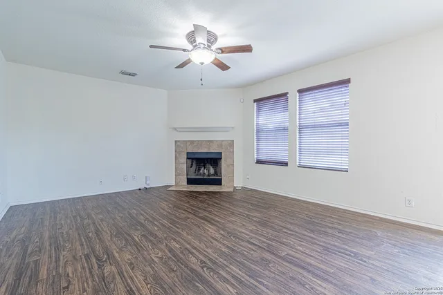 a view of empty room with wooden floor and fireplace