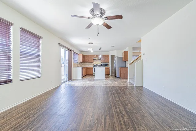 a view of a kitchen with a sink a ceiling fan and wooden floor