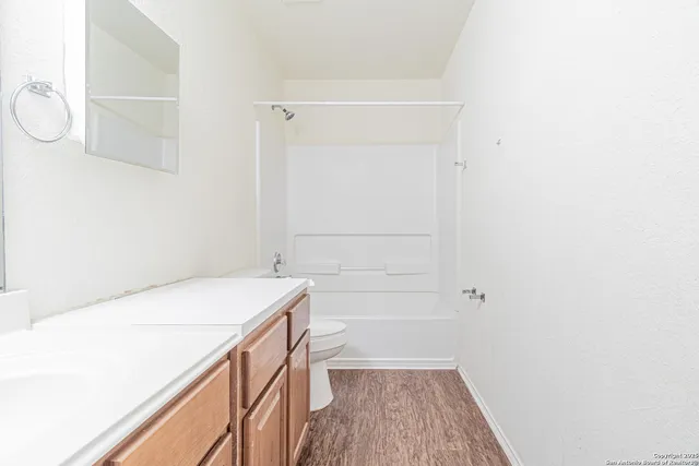 an empty room with a window and a ceiling fan