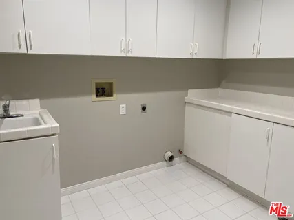 a view of cabinets and utility room with closet