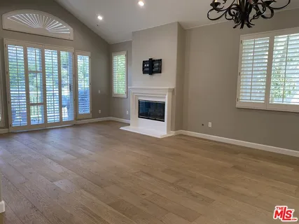 a view of an empty room with a window and fireplace