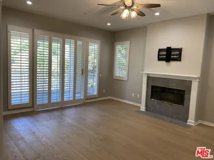 a view of an empty room with a fireplace and a window