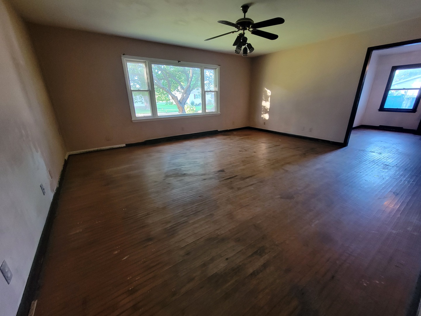 204 Williams Street Henry, IL 61537 - Photo 11 of 35 an empty room with wooden floor chandelier fan and windows
