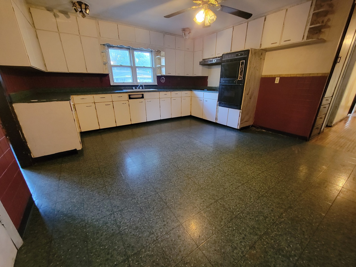 204 Williams Street Henry, IL 61537 - Photo 12 of 35 a kitchen with stainless steel appliances a refrigerator a sink a stove white cabinets and wooden floor