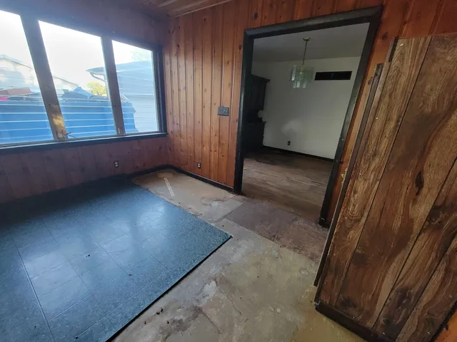 a view of an empty room with closet and wooden floor