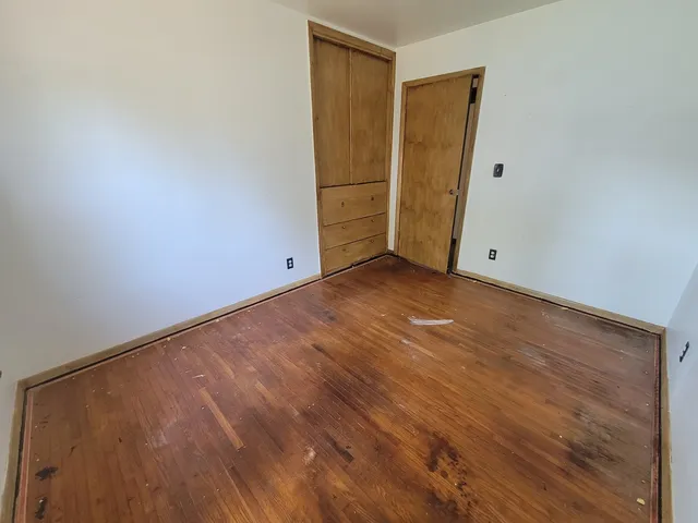 a view of an empty room and wooden floor