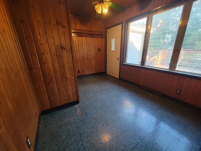 a view of an empty room with window and cabinet