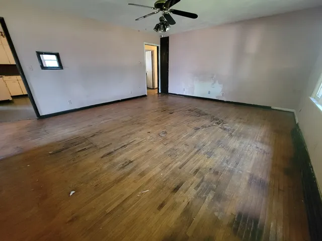 a view of room with a ceiling fan and wooden floor