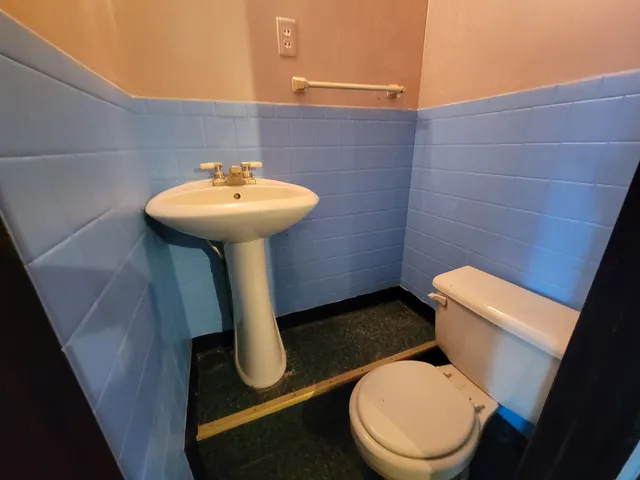 a bathroom with a toilet a sink and a mirror
