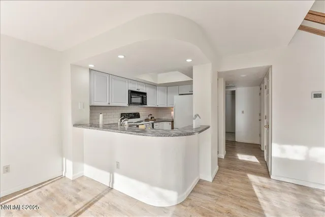 a kitchen with stainless steel appliances granite countertop a sink and a white cabinets