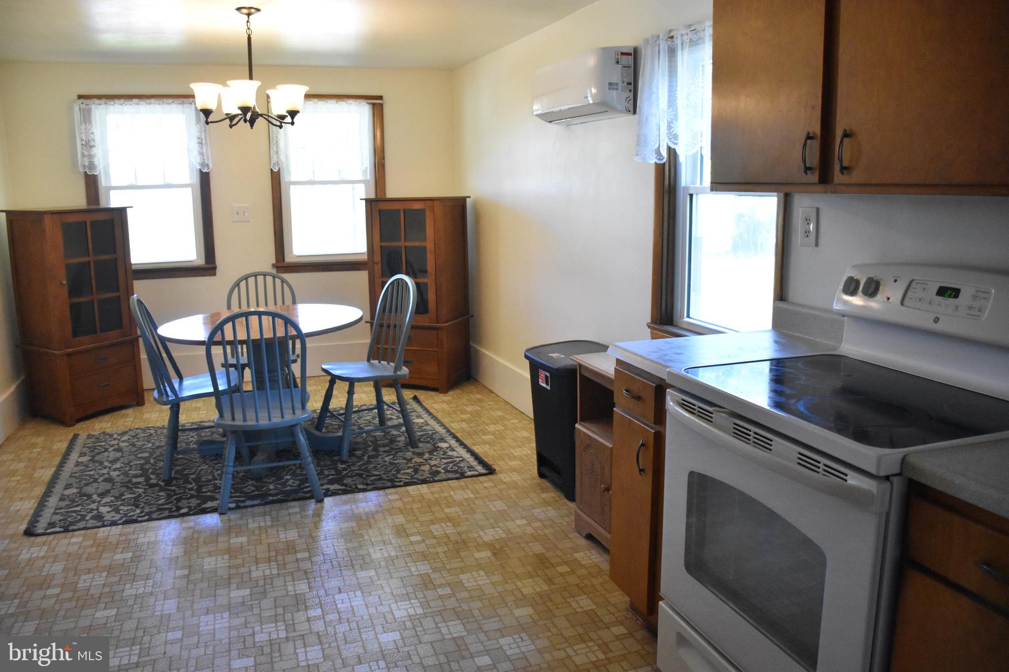 1362 New Road Orrtanna, PA 17353 - Photo 18 of 28 a kitchen with stainless steel appliances granite countertop a stove top oven a sink a dining table and chairs with wooden floor