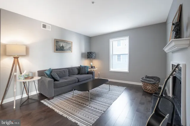 a living room with furniture a desk and chair with wooden floor