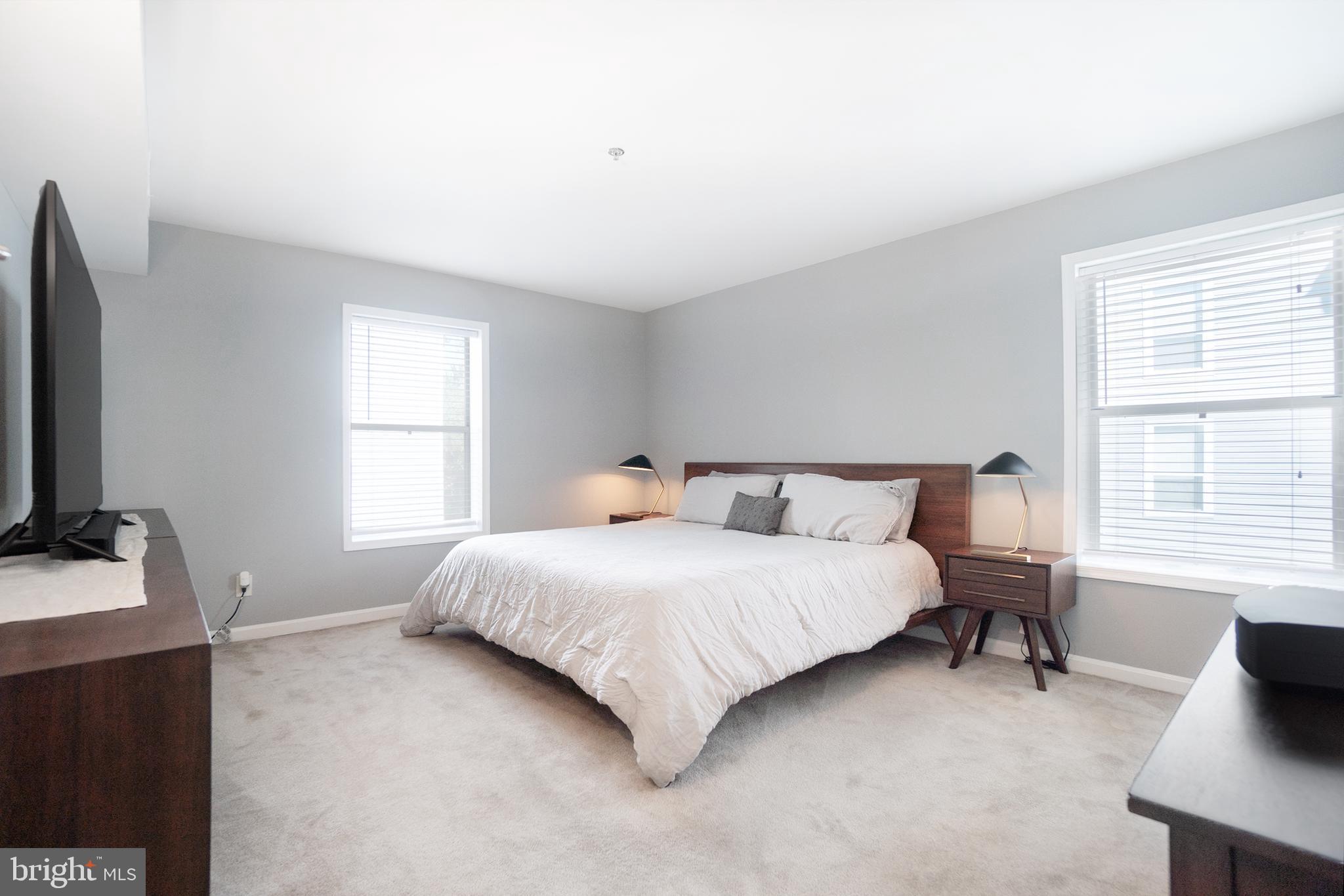 10248 Appalachian Circle, Unit 1D7 Oakton, VA 22124 - Photo 21 of 32 a bedroom with a bed a table and a flat screen tv