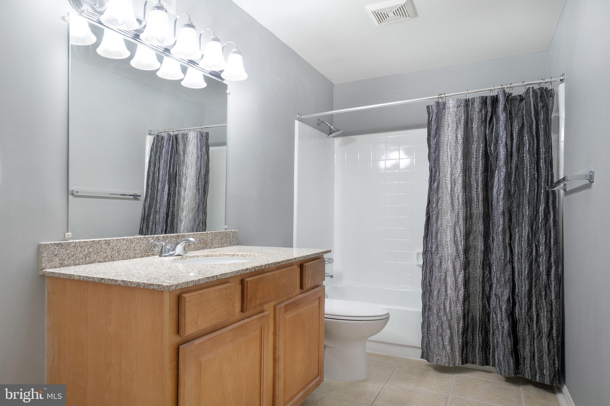 10248 Appalachian Circle, Unit 1D7 Oakton, VA 22124 - Photo 23 of 32 a bathroom with a granite countertop sink a toilet and a mirror