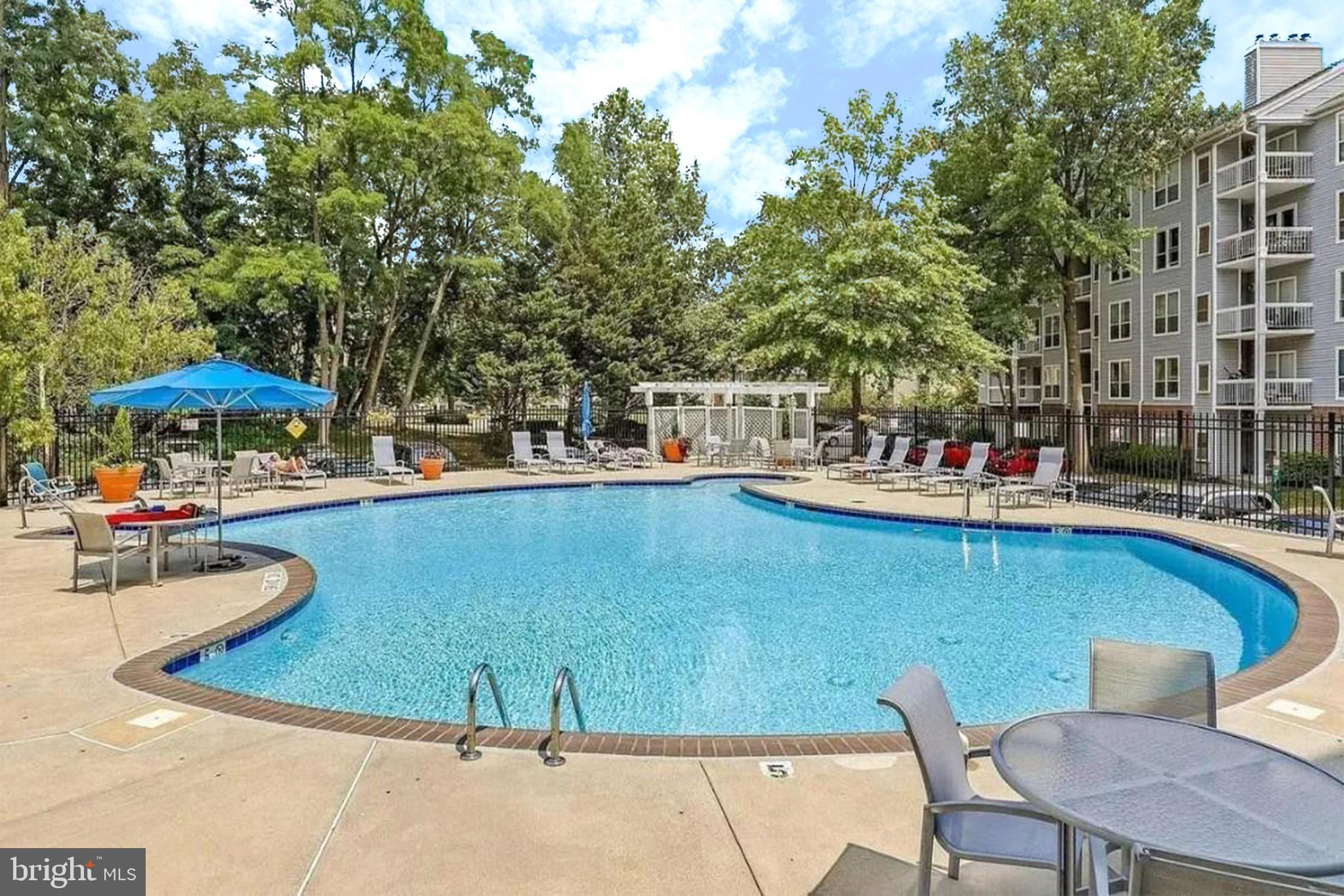 10248 Appalachian Circle, Unit 1D7 Oakton, VA 22124 - Photo 27 of 32 a view of a swimming pool with chairs in patio