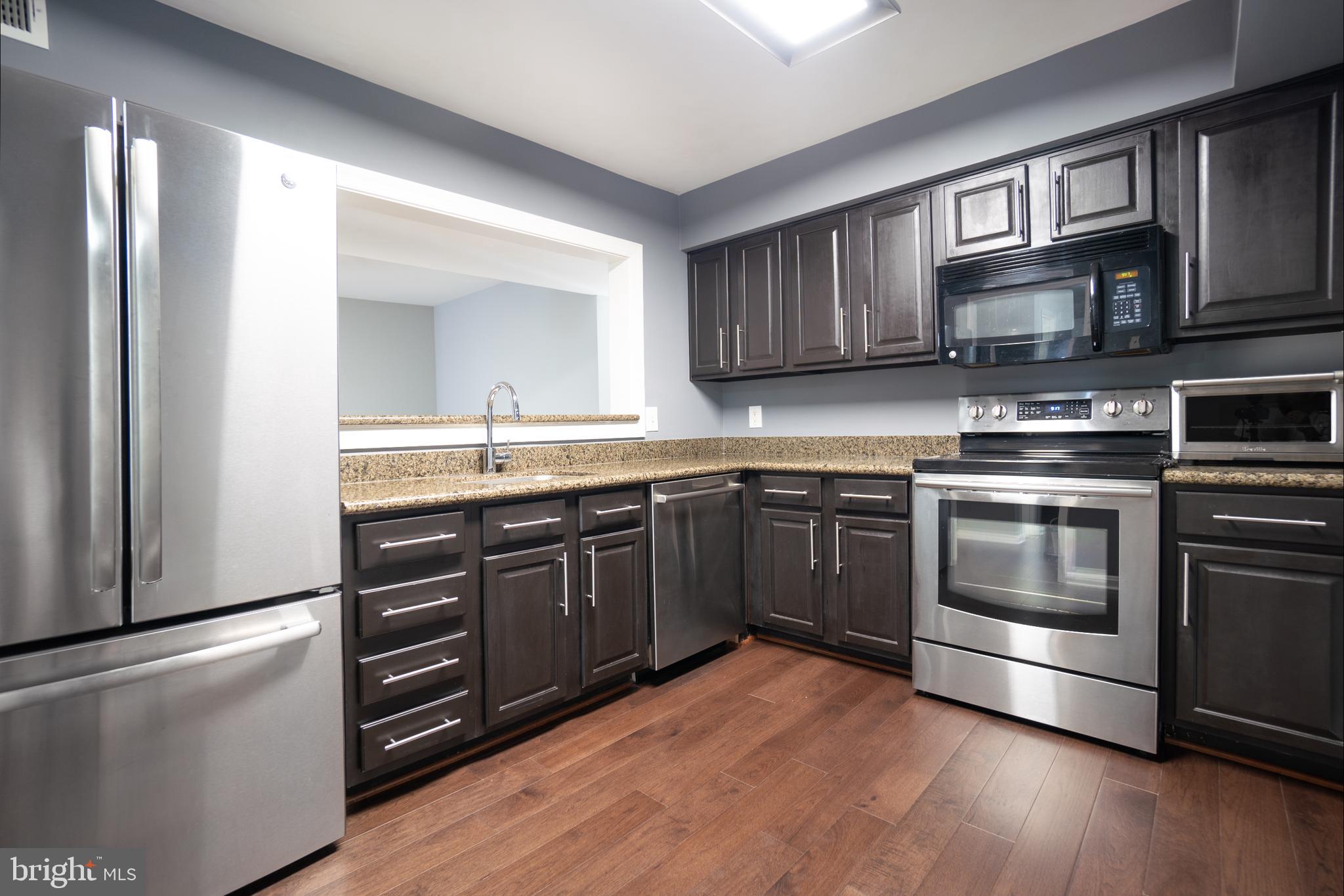 10248 Appalachian Circle, Unit 1D7 Oakton, VA 22124 - Photo 5 of 32 a kitchen with stainless steel appliances granite countertop a stove and a sink