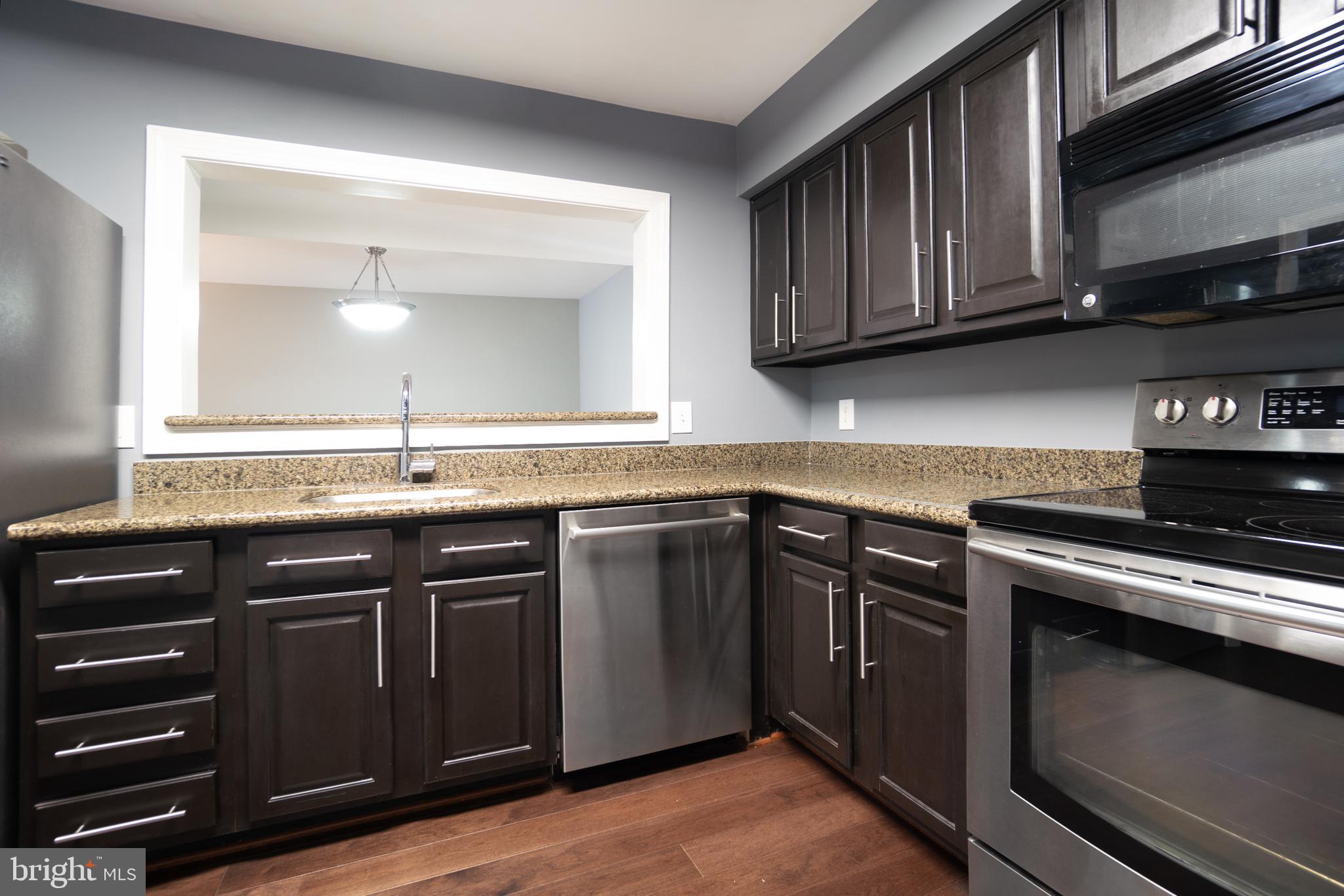 10248 Appalachian Circle, Unit 1D7 Oakton, VA 22124 - Photo 6 of 32 a kitchen with granite countertop stainless steel appliances a stove sink and cabinets