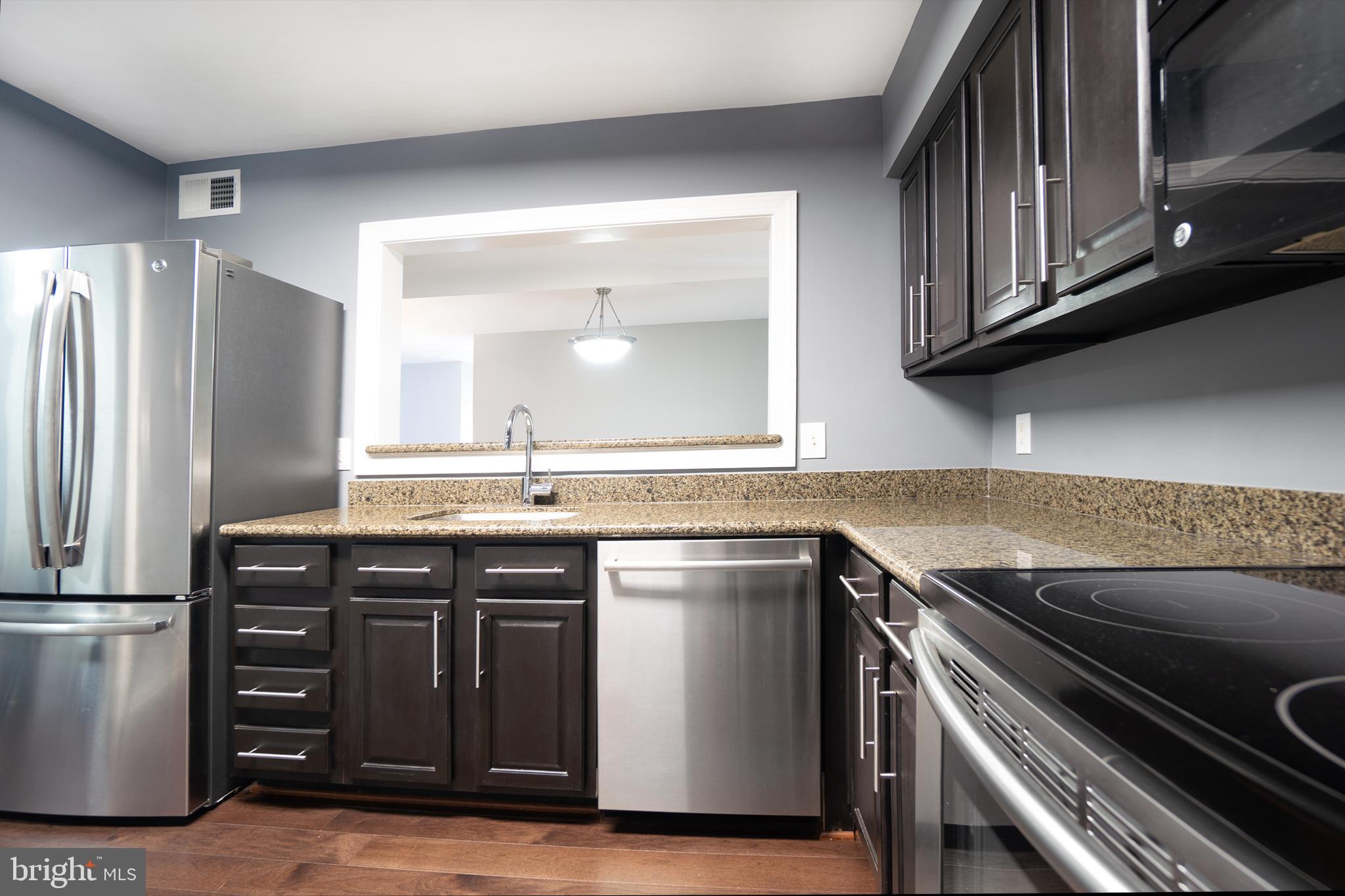 10248 Appalachian Circle, Unit 1D7 Oakton, VA 22124 - Photo 8 of 32 a kitchen with stainless steel appliances granite countertop a sink stove and refrigerator