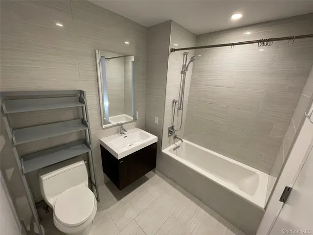 a bedroom with a bed and a flat tv screen on the dresser