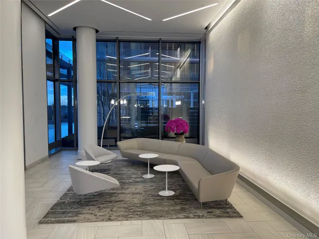 a living room with furniture kitchen view and a window