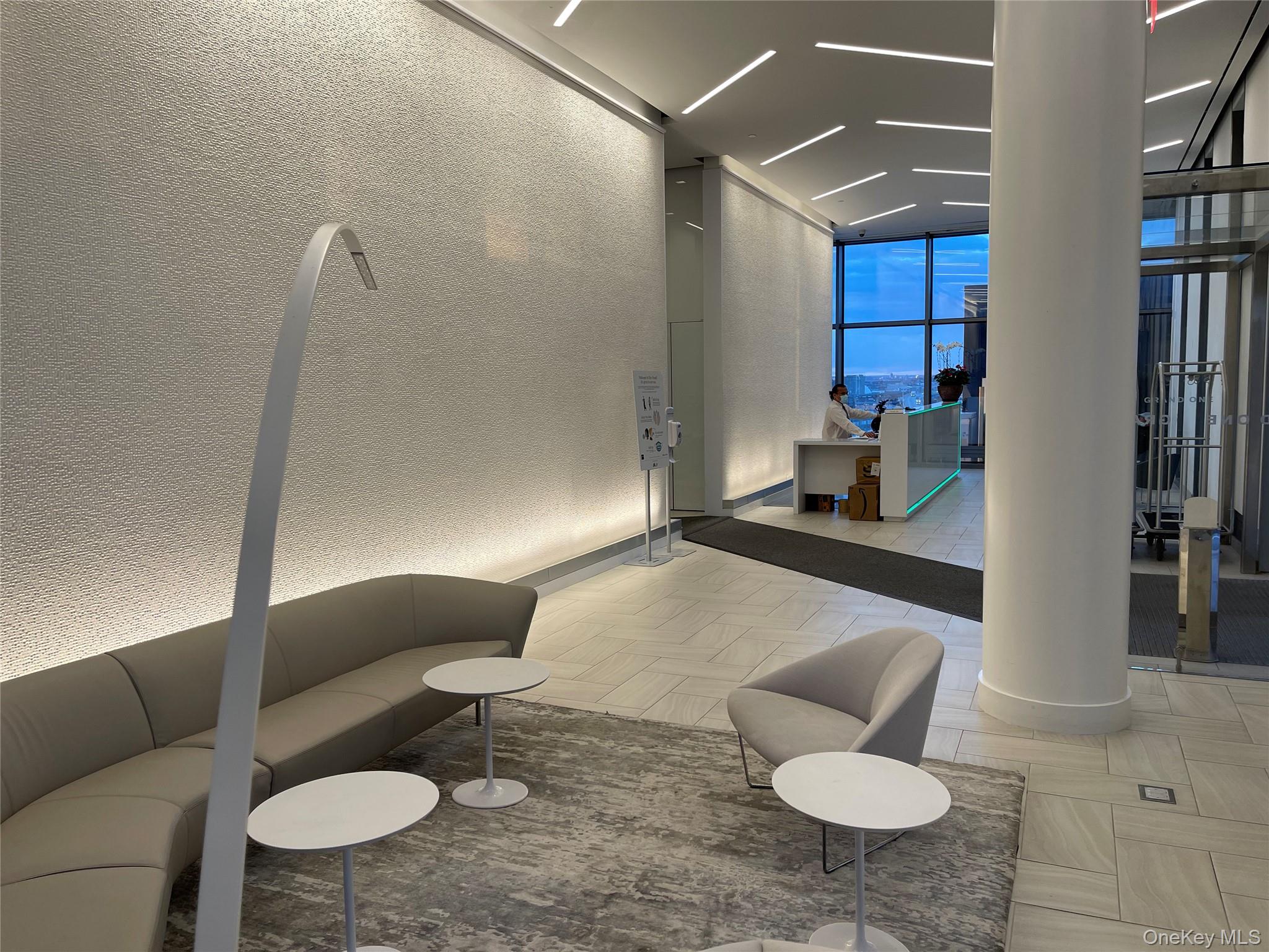 131-05 40 Road, Unit PH1D Queens, NY 11354 - Photo 16 of 23 Building lobby featuring a wall of windows and a textured wall