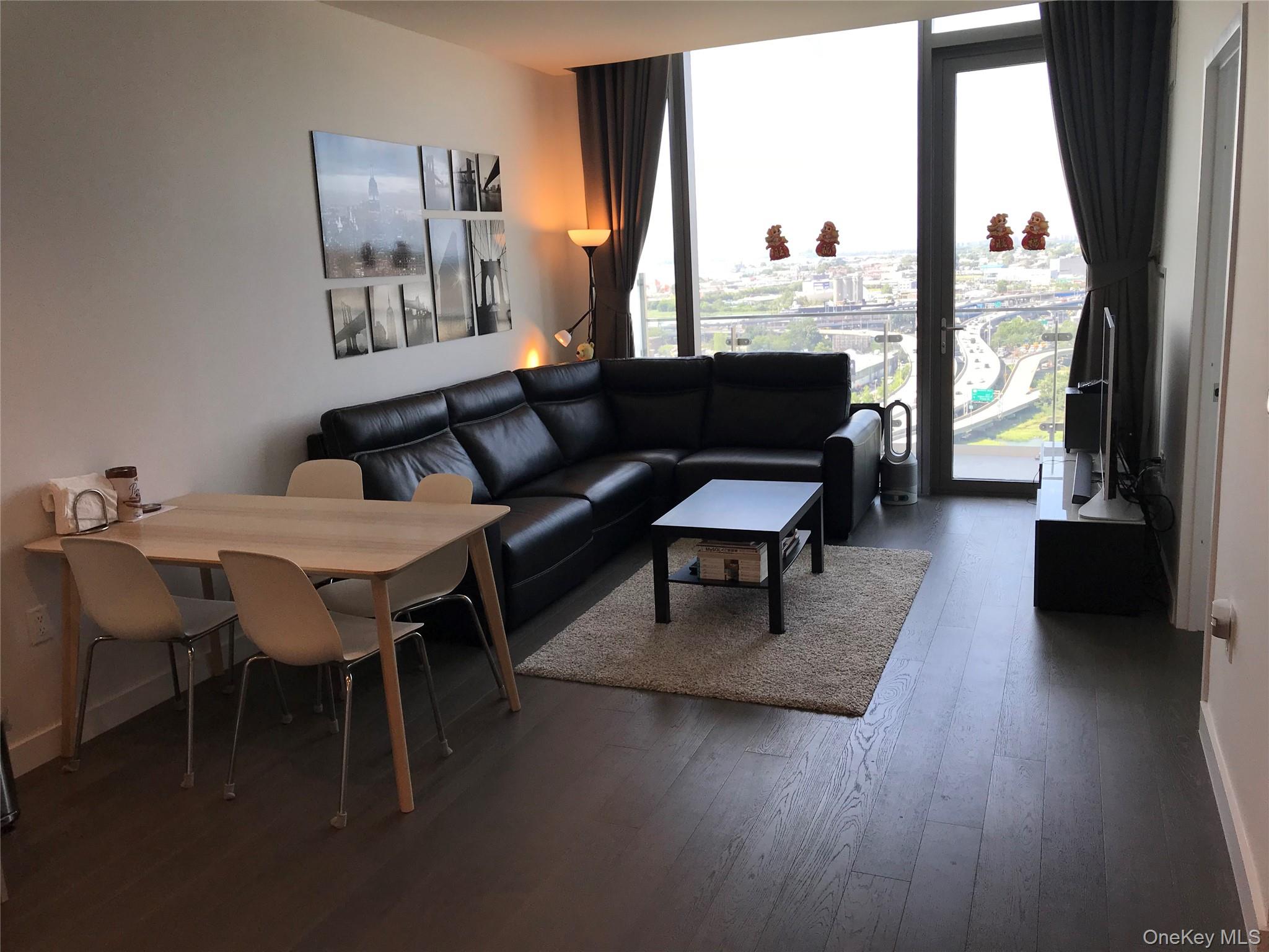 131-05 40 Road, Unit PH1D Queens, NY 11354 - Photo 5 of 23 Living room featuring floor to ceiling windows and dark wood-style flooring