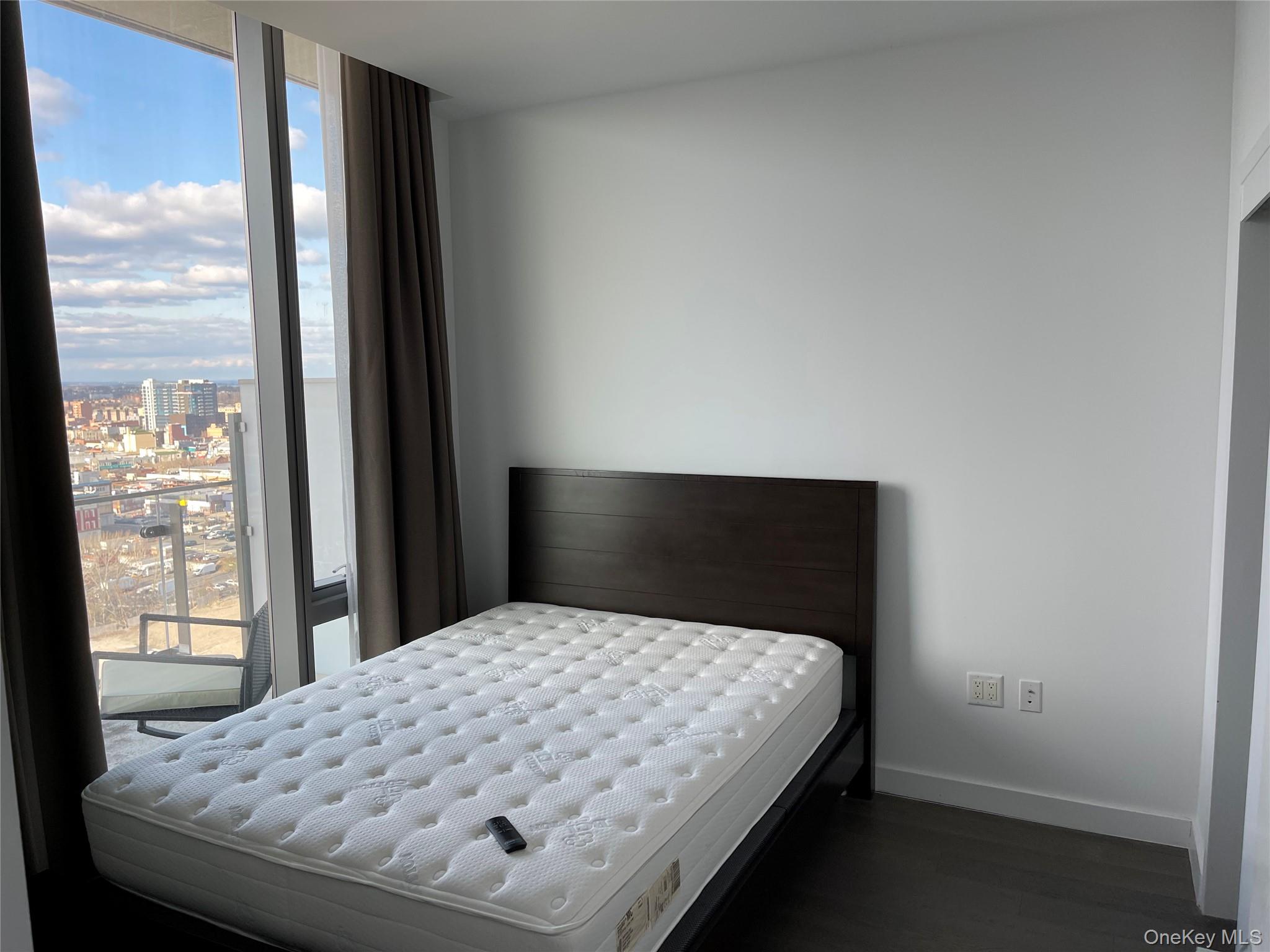131-05 40 Road, Unit PH1D Queens, NY 11354 - Photo 8 of 23 Bedroom featuring a city view, dark wood-type flooring, and a wall of windows