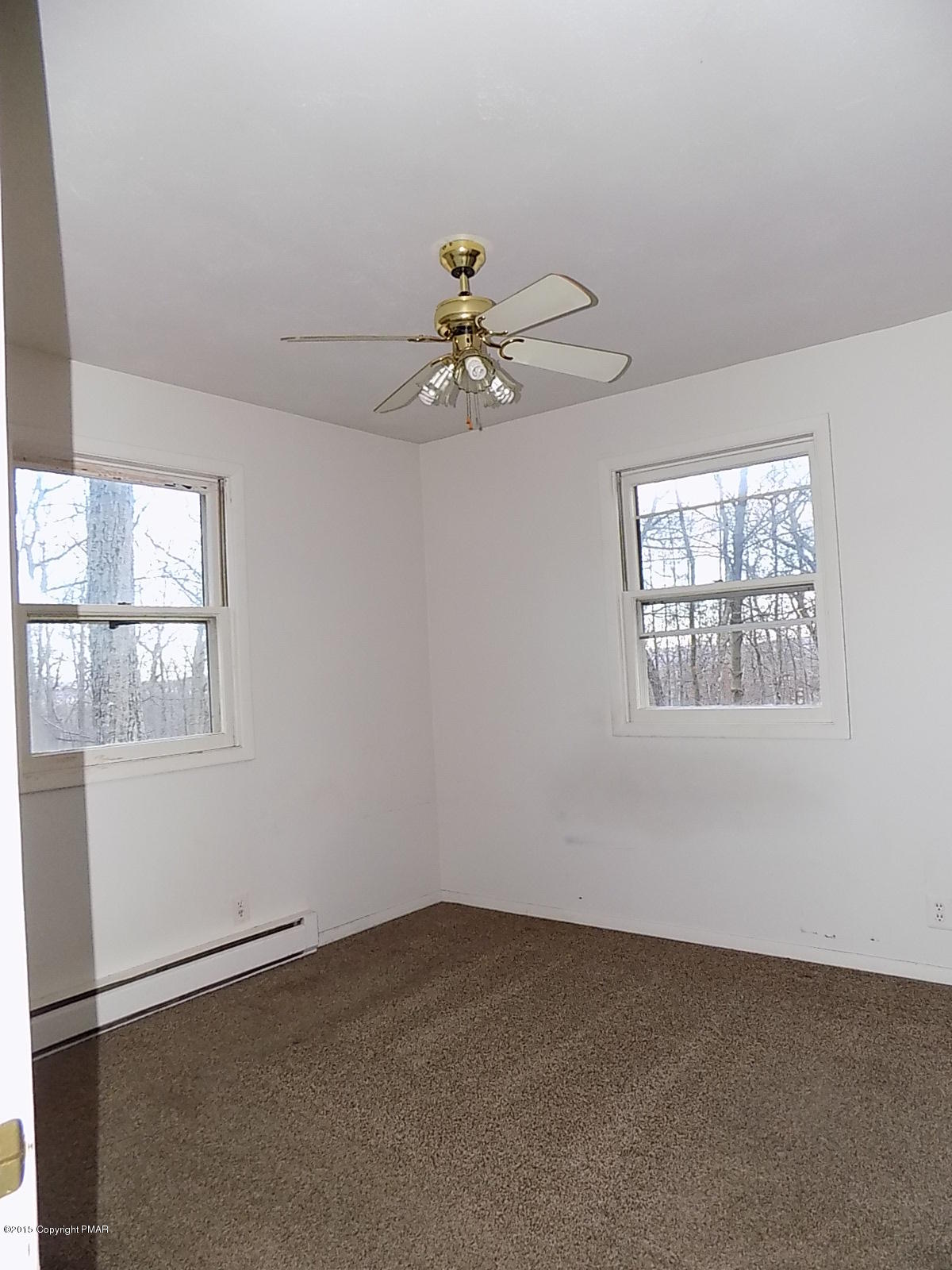 856 Gold Finch Road Bushkill, PA 18324 - Photo 3 of 10 an empty room with windows and chandelier fan