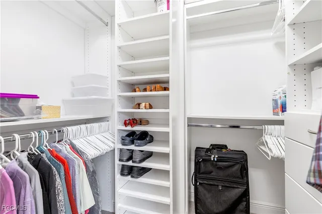 a view of walk in closet with clothes and shoes