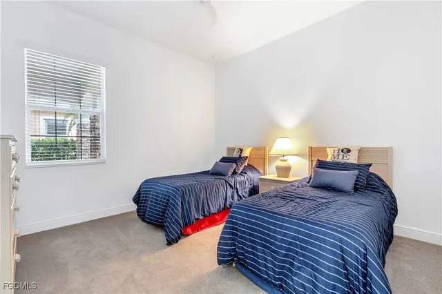 a bedroom with two beds and a window