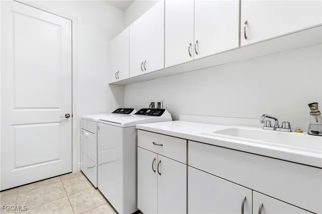 a kitchen with white cabinets and sink