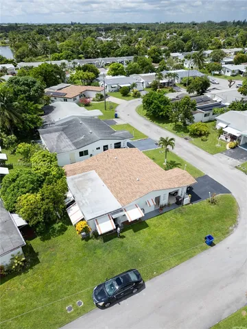an aerial view of a house with a garden and lake view