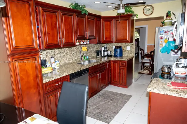 a kitchen with granite countertop wooden cabinets a sink a stove and a window