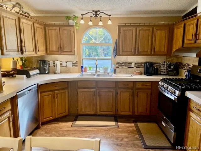 a kitchen with stainless steel appliances granite countertop a sink stove and cabinets